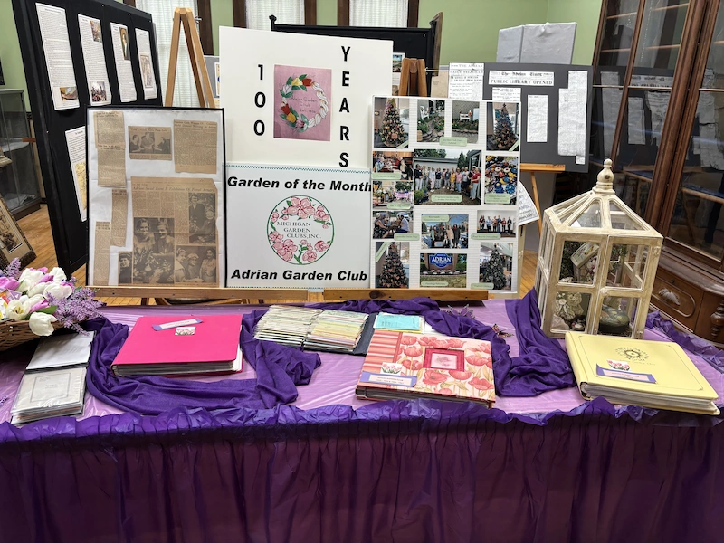 Table display showing Adrian Garden Club items.