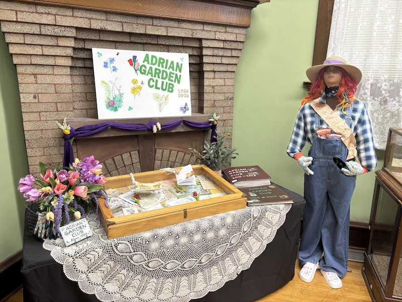 Table display showing Adrian Garden Club items along with mannequin of gardener